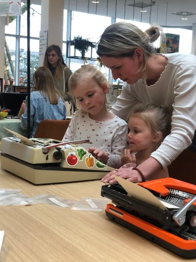 Cultuurhuis De Cammeleur Moeder met twee dochters bij een kleurrijke typemachine