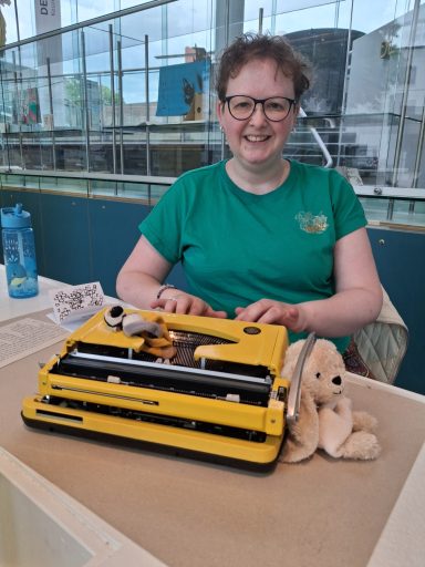 Type-in bij CODA vrouw achter typemachine met knuffels